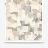 Wallpaper roll in a geometric puzzle piece watercolor pattern in beige and grey. 