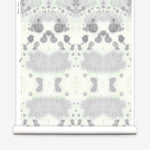 Wallpaper roll in a watercolor inkblot print in shades of blue-gray on a cream field.