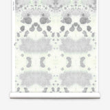Wallpaper roll in a watercolor inkblot print in shades of blue-gray on a cream field.