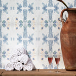 Wallpaper installed behind a plunge pool with props in a watercolor ink splash print in shades of pastel blue and pink on a cream field.