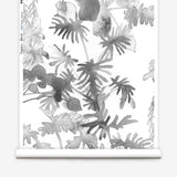 Wallpaper roll in an watercolor palm frond pattern in shades of grey.