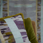 Decorative pillow with fringe in a watercolors stripe design.