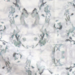 Detail of fabric in a watercolor paint blotch print in gray and turquoise on a white field.