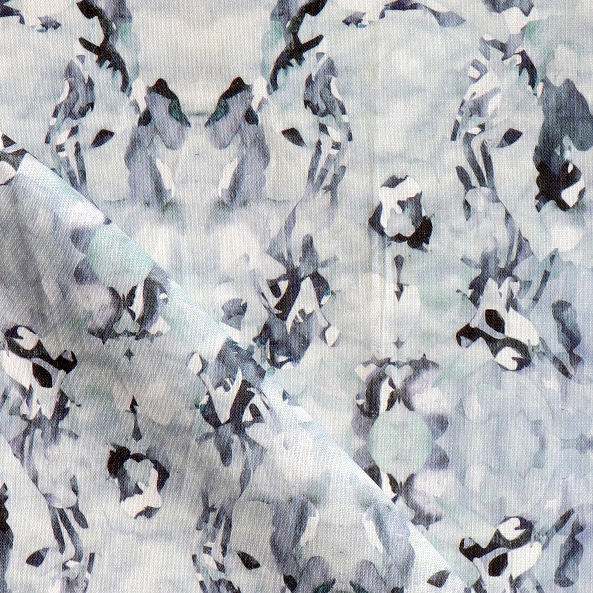 Detail of fabric in a watercolor paint blotch print in blue, gray and purple on a white field.