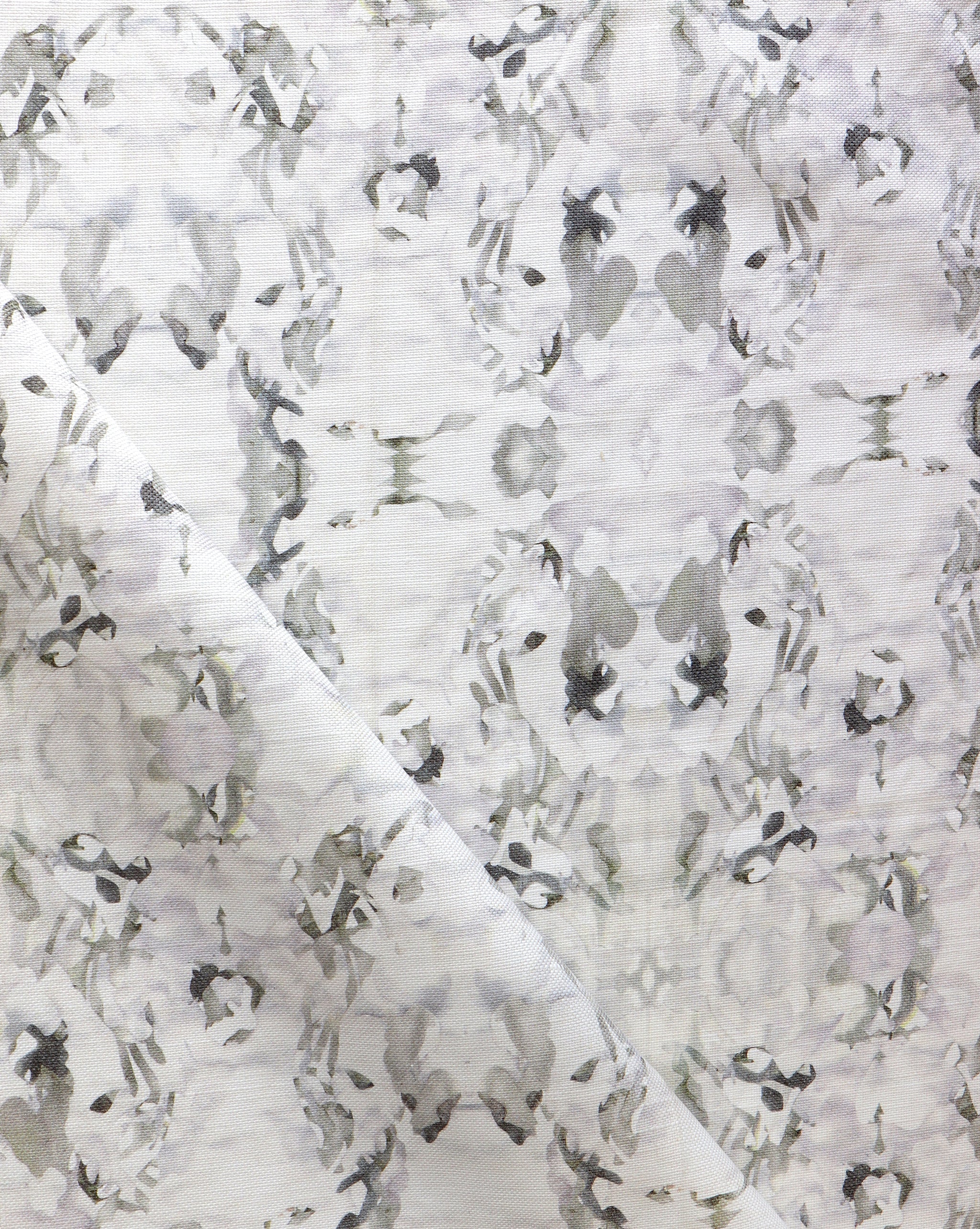 Detail of fabric in a watercolor paint blotch print in purple and gray on a white field.