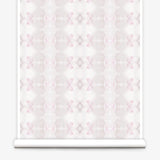 Partially unrolled wallpaper yardage in a striped ink blot print in shades of tan and pink on a cream field.