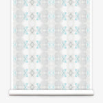 Partially unrolled wallpaper yardage in a striped ink blot print in shades of gray and turquoise on a cream field.