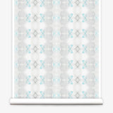 Partially unrolled wallpaper yardage in a striped ink blot print in shades of gray and turquoise on a cream field.