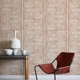 Modern brown chair with black frame against a brown geometric wallpaper