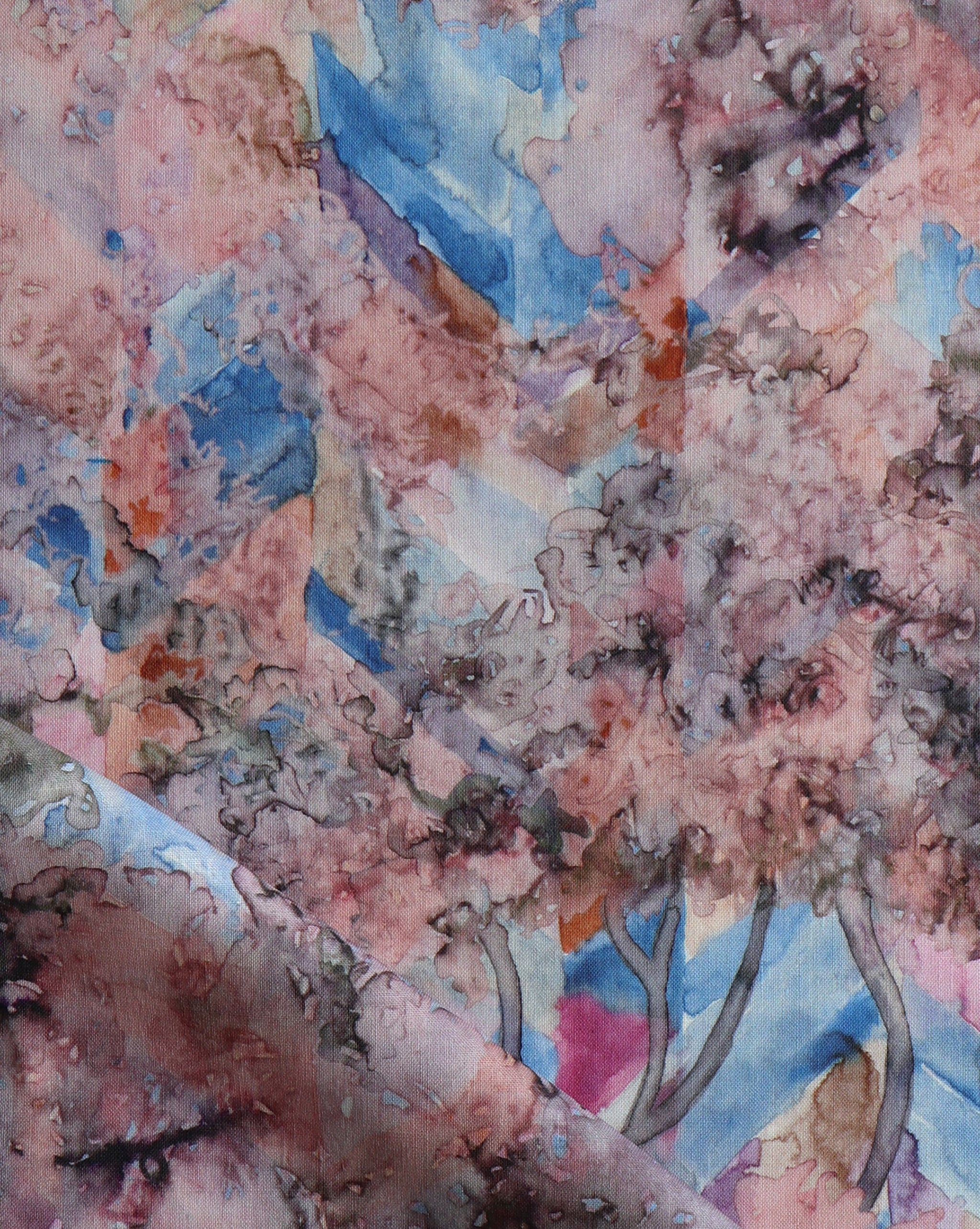Detail of fabric in a painterly tree print in pink, orange, gray and blue.