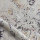 Detail of fabric in a painterly tree print in gray, brown and purple.