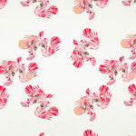 Detail of fabric in a playful feather print in pink, purple and orange on a cream field.