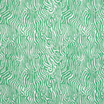Detail of fabric in a playful animal print in light green on a white field.