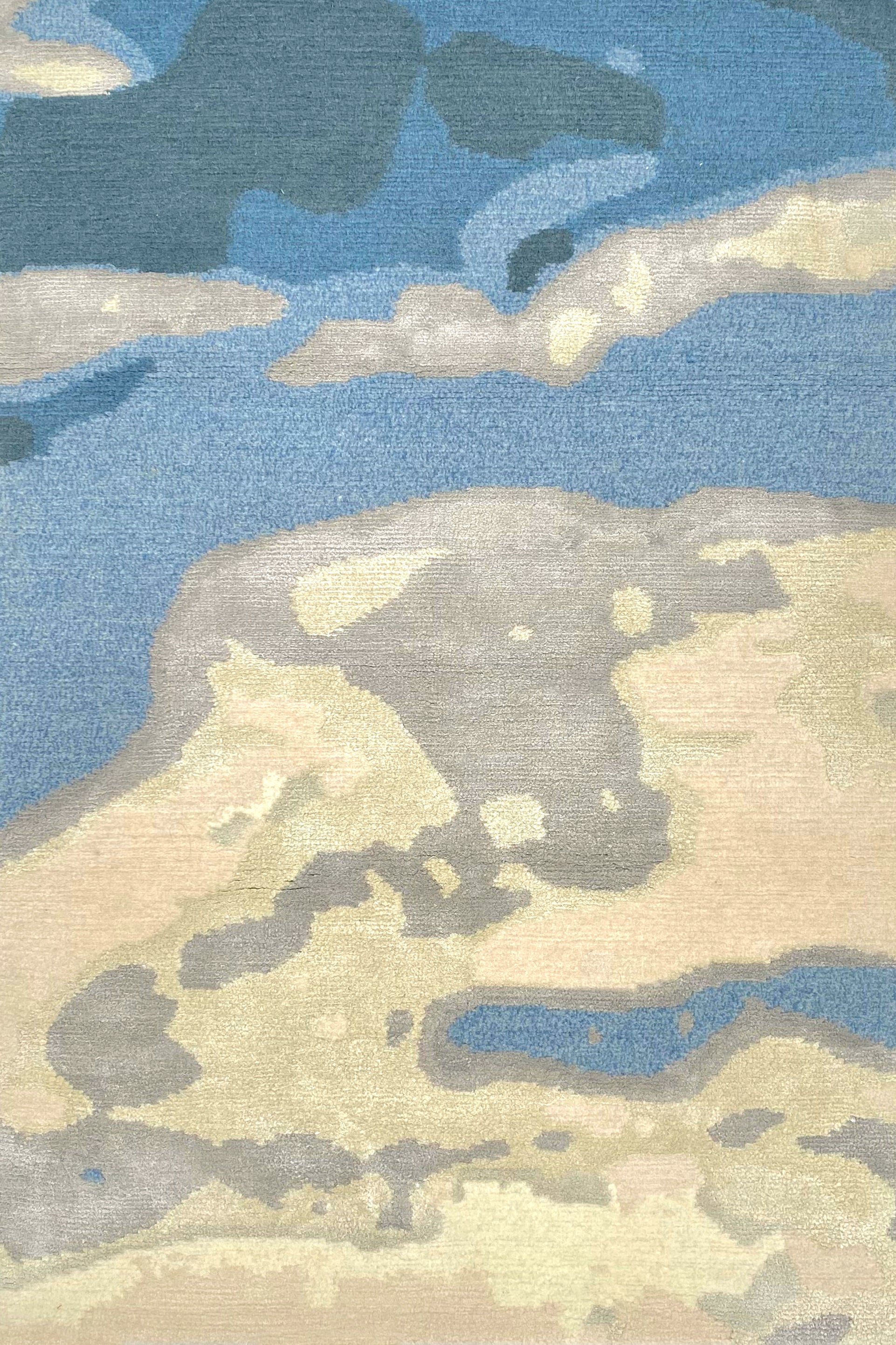 Handknotted rug in an abstract watercolor design in shades of blue, grey and cream.