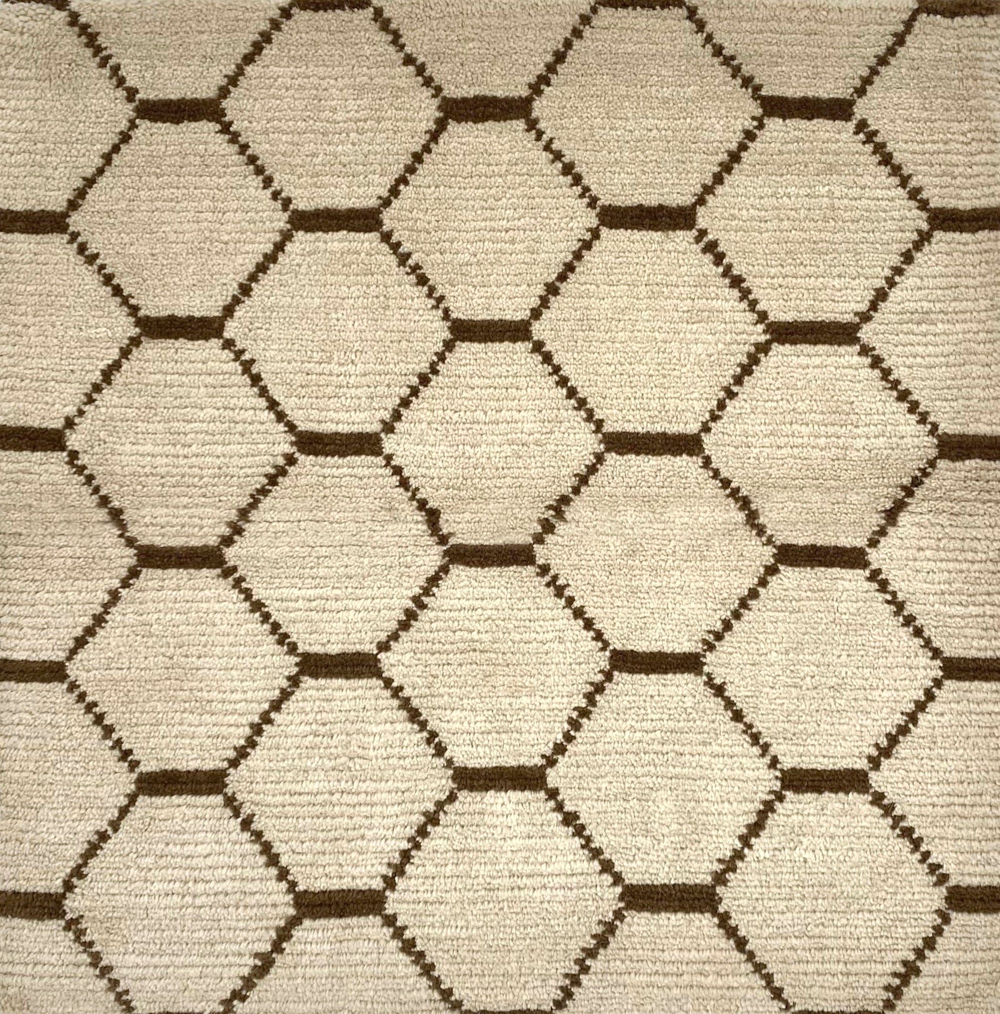 Handknotted Moroccan style rug with a brown lattice on a cream field.