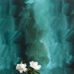 A vase of flowers stands in front of a wall papered in an abstract curvilinear pattern in mottled turquoise and black.