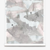 Roll of wallpaper with abstract watercolor design in shades of grey. 