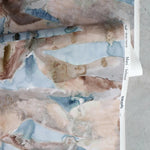 Wallpaper in a watercolor design in brown and grey gently draped on itself. 