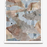 Roll of wallpaper with abstract watercolor design in shades of brown and blue.