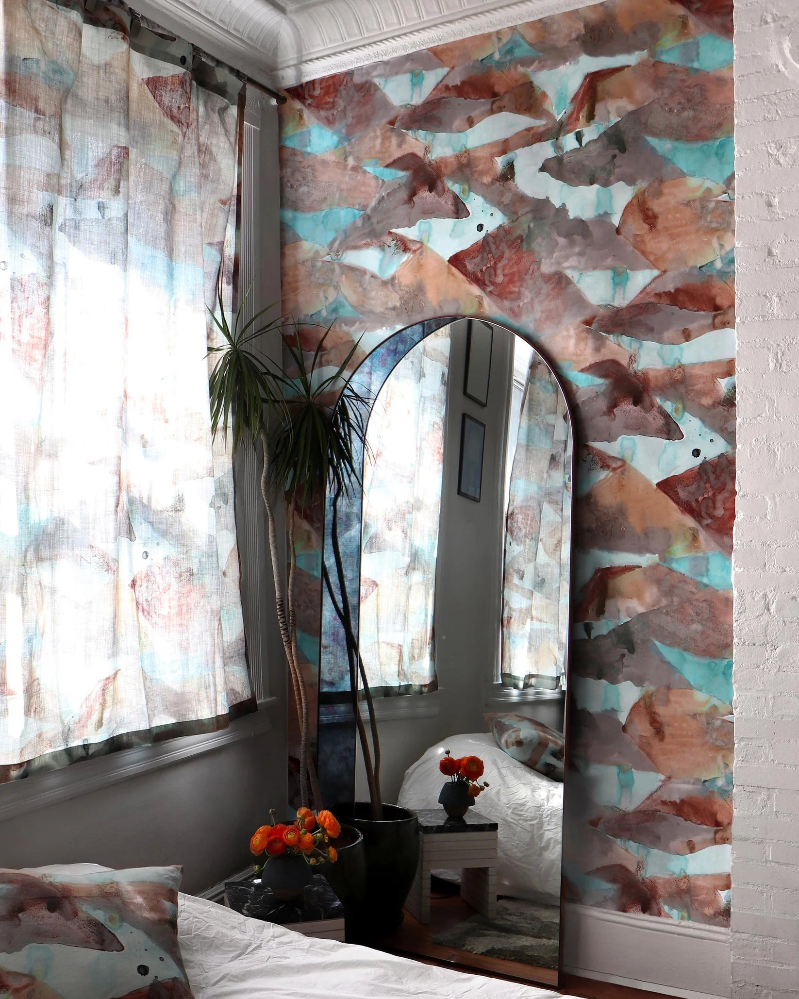 Room interior with abstract wallpaper in brown and teal, a mirror, and decorative elements.