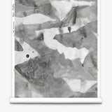 Roll of wallpaper with abstract watercolor design in shades of grey. 