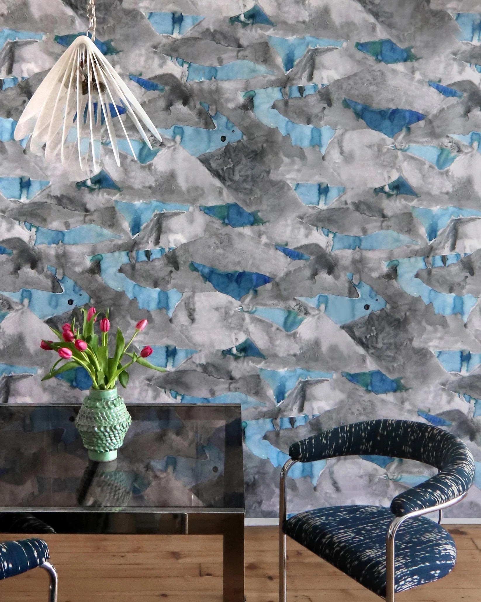 Room interior with abstract patterned wallpaper, table, and chairs.