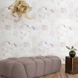 Modern beige ottoman in a room with watercolor check-patterned wallpaper and a decorative light fixture.
