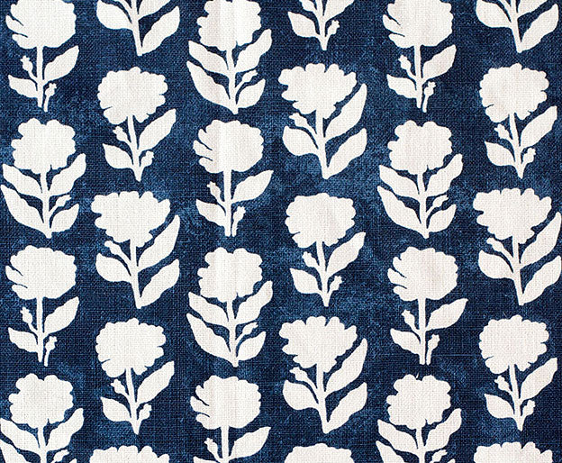 Detail of fabric in a classic floral silhouette print in cream on a pink field