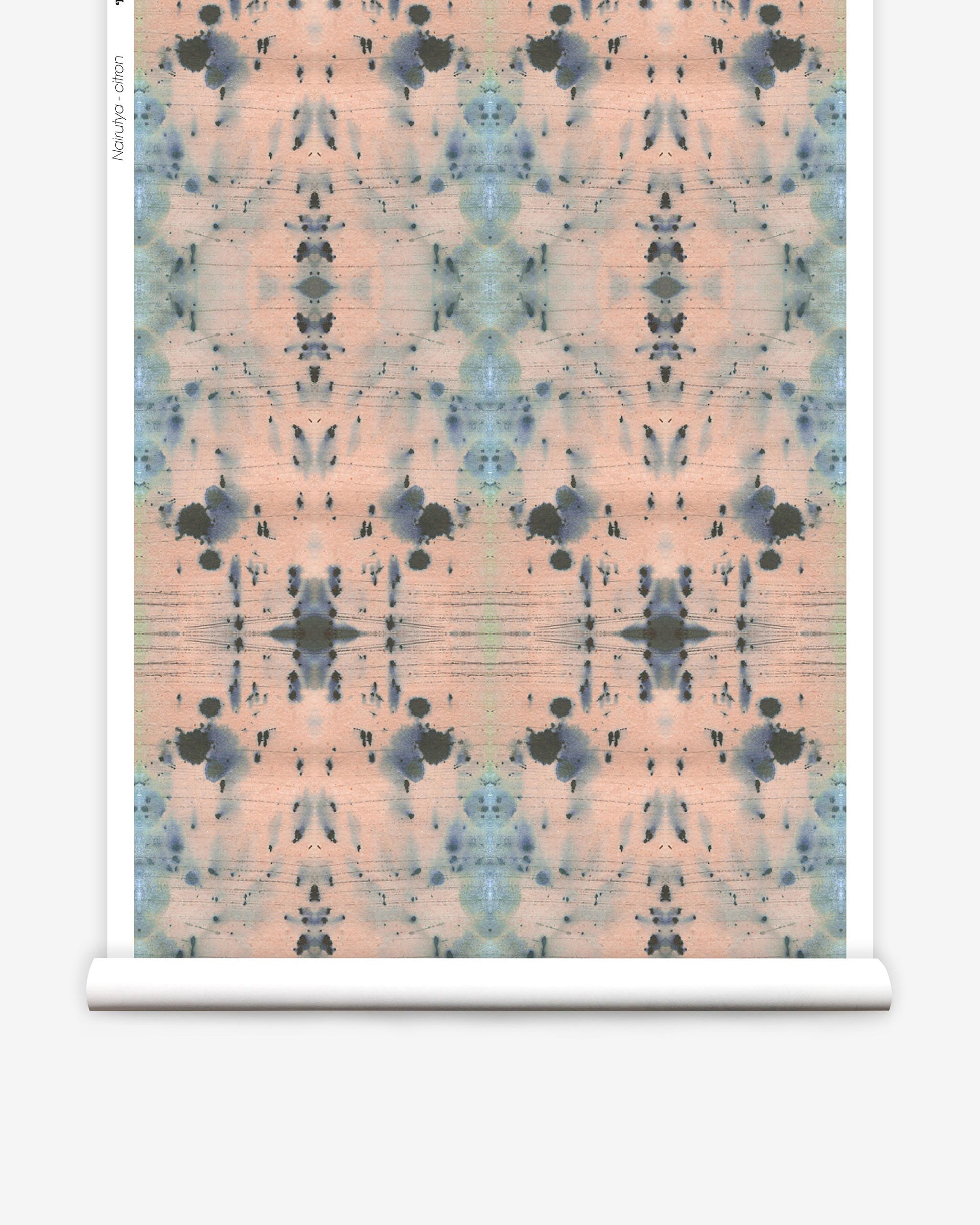Partially unrolled wallpaper yardage in a watercolor ink blot print in blue and gray on a light pink field.