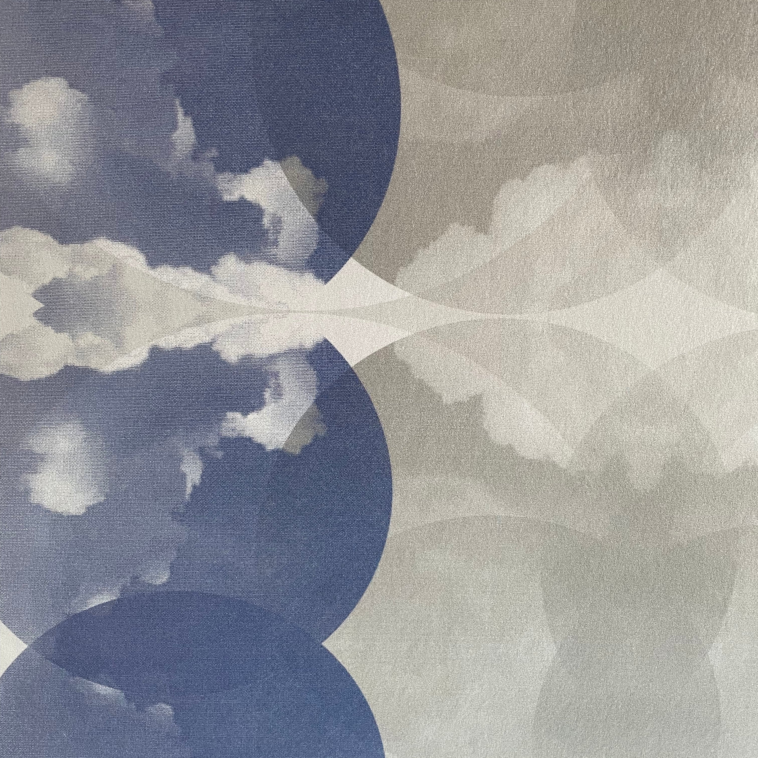 Close-up of wallpaper in a cloudy ink blot print in shades of blue and gray on a cream field.