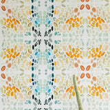 A potted cactus stands in front of a wall papered in a painterly grid print in blue, gray, and orange on a cream field.