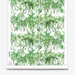 Partially unrolled wallpaper yardage in a painterly palm tree stripe print in green and white.