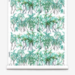 Partially unrolled wallpaper yardage in a painterly palm tree stripe print in green, gray and white.
