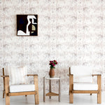 A modernist living tableau with a wall papered in a painterly palm tree stripe print in cream, gray and white.