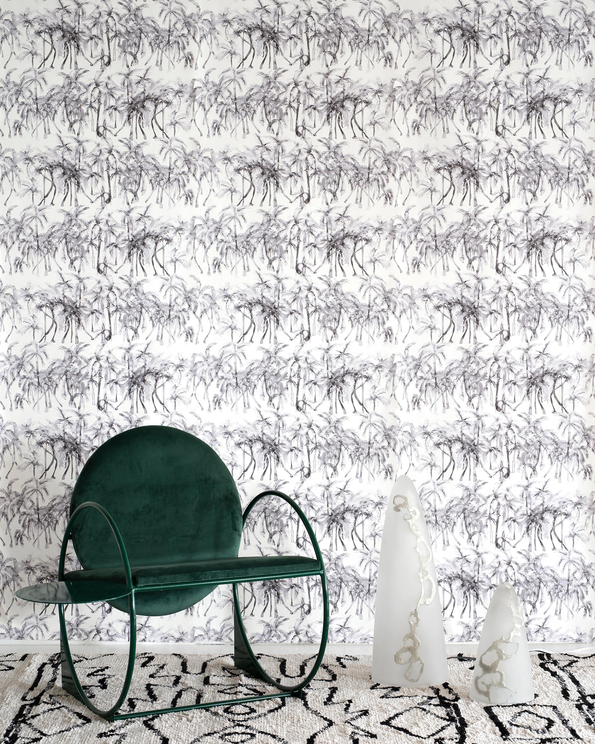 A modernist living tableau with a wall papered in a painterly palm tree stripe print in gray and white.