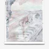 Partially unrolled wallpaper yardage in a watercolor painterly print in shades of pink, gray and white.