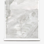 Partially unrolled wallpaper yardage in a watercolor painterly print in shades of gray and cream.