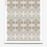 Partially unrolled wallpaper yardage in a watercolor ink blot pattern in shades of tan, turquoise and pink.