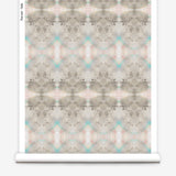 Partially unrolled wallpaper yardage in a watercolor ink blot pattern in shades of tan, turquoise and pink.
