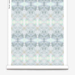 Partially unrolled wallpaper yardage in a watercolor ink blot pattern in shades of gray, green and pink.