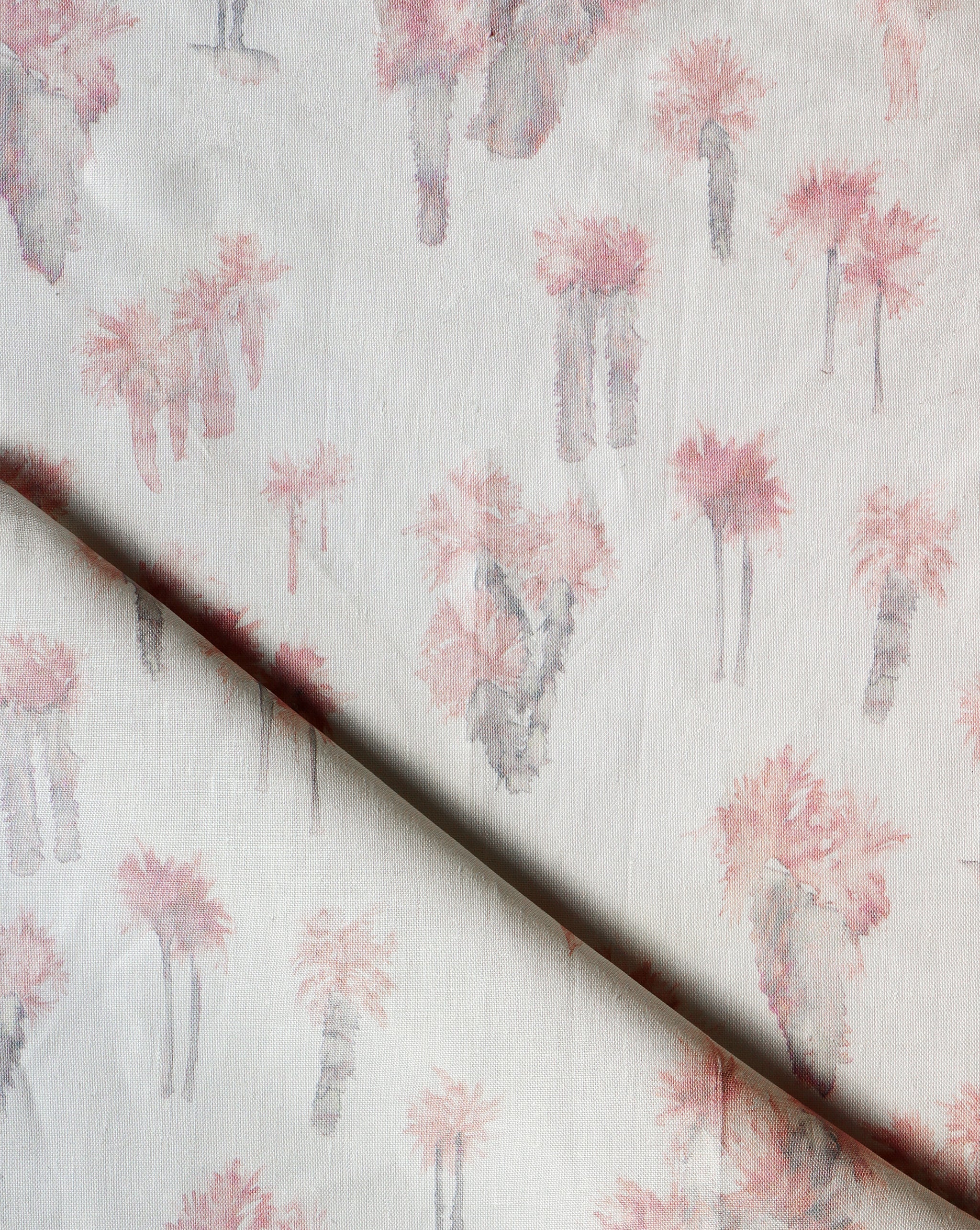 Draped fabric yardage in a painterly palm tree print in shades of pink and gray on a white field.
