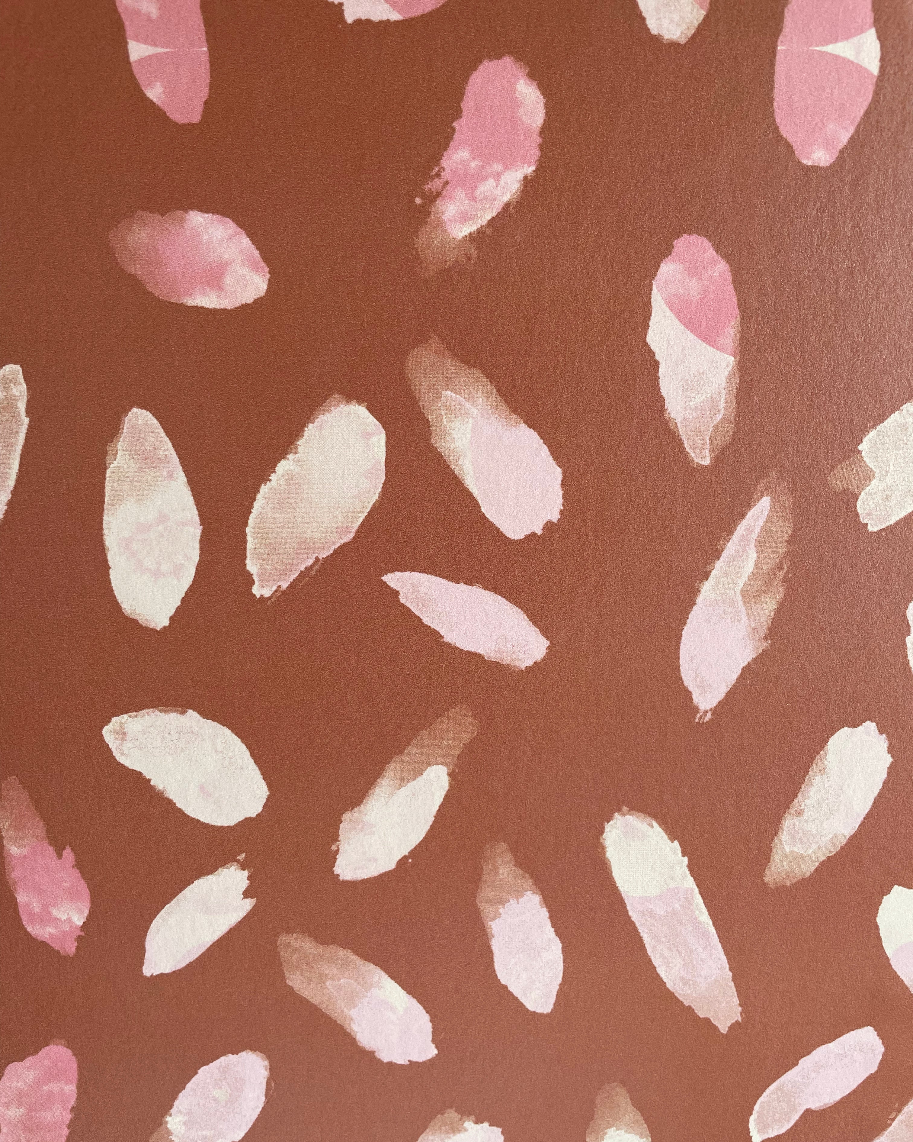 Detail of wallpaper in a playful paint blotch print in shades of pink and cream on a brown field.