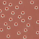 Detail of fabric in a minimal floral print in shades of pink, red and blue on a maroon field.
