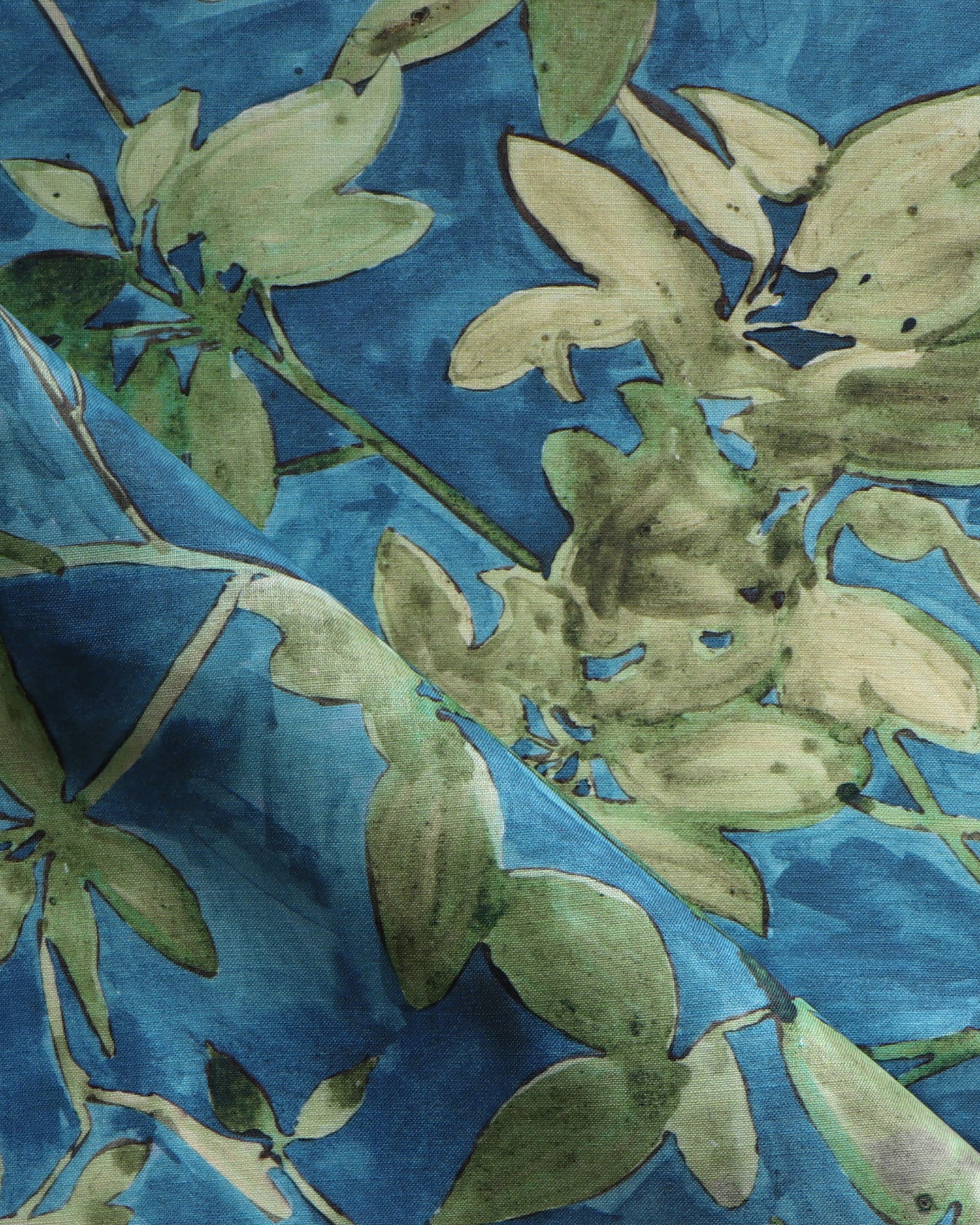 Close-up of a fabric with green floral pattern on blue background