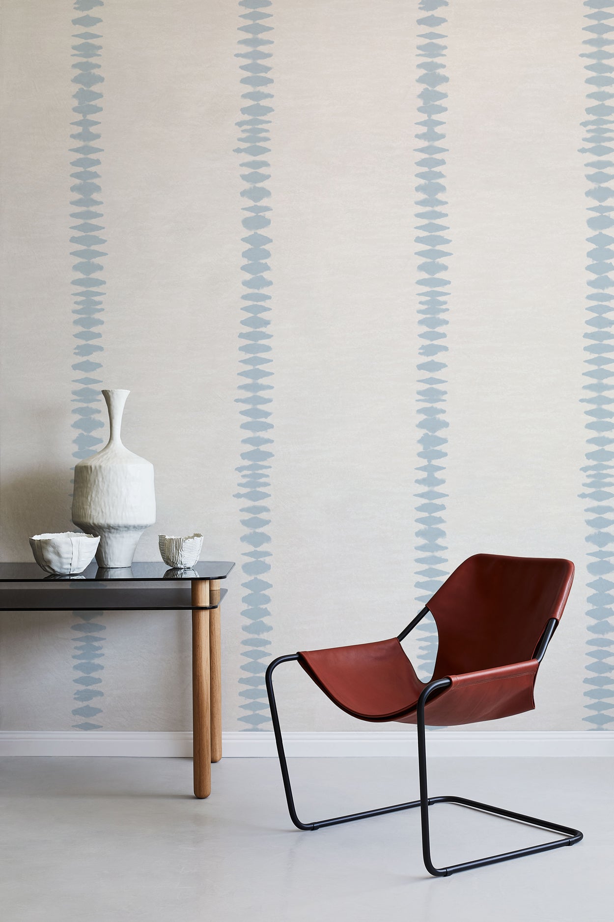 Modern brown chair and table against a wall with decorative blue stripes