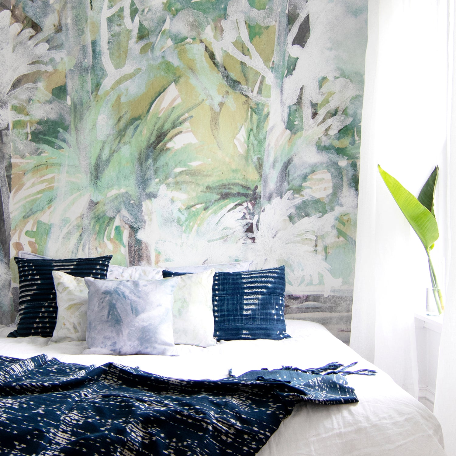 Bedroom with tropical mural wall and decorative pillows