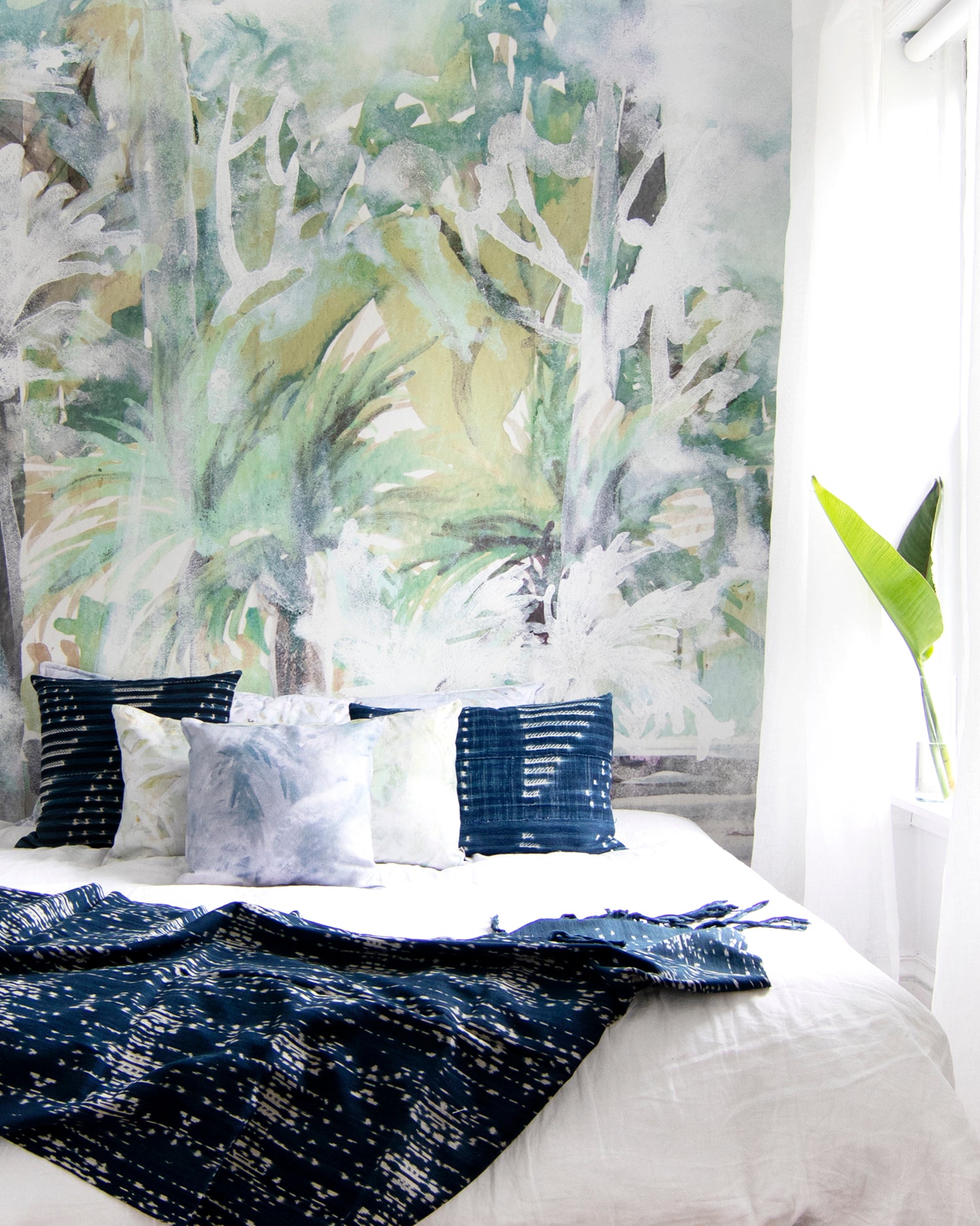 Bedroom with tropical mural wall and decorative pillows