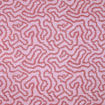 Printed fabric in a meandering hand drawn line pattern in red on a pink field. 