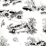 A vase of flowers stands in front of a wall covered in a playful illustrated car crash print in black on a white field.