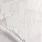 Draped fabric yardage in a watercolor watercolor print in shades of gray and purple on a white field.